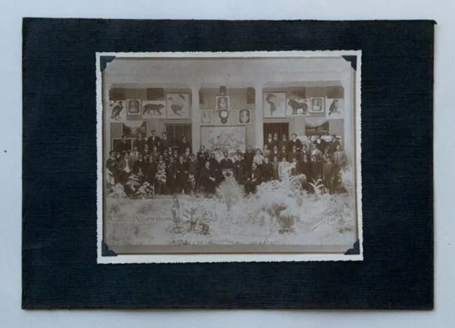 Retrato de alumnos con sus útiles y profesores en un patio de la escuela