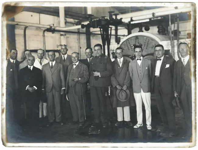 Reunión de señores en recinto industrial.
