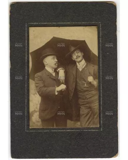 Retrato de dos hombres bajo un paraguas