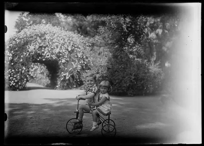 Retrato de dos niños en triciclo