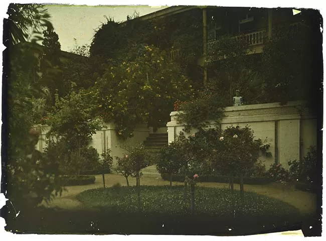 Niña en jardín y entrada de casona