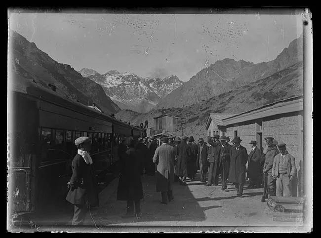 Personas en estación de tren en paisaje cordillerano