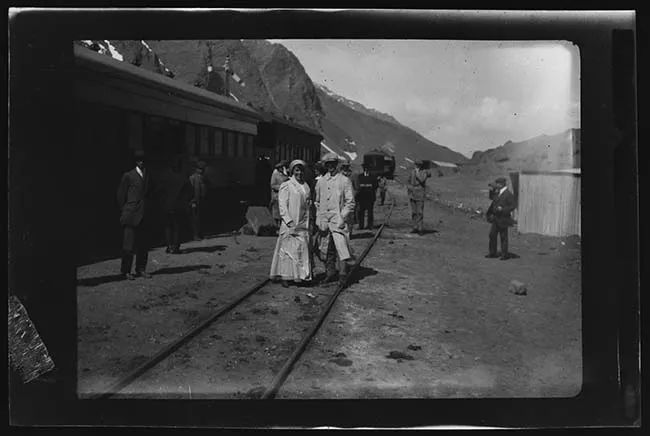 Pareja junto a tren en camino cordillerano
