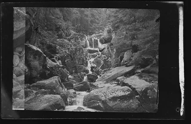 Hombre y niña en cascada de arroyo 