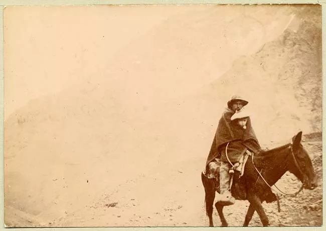 Hombre y niño montados en burro en Cordillera de los Andes