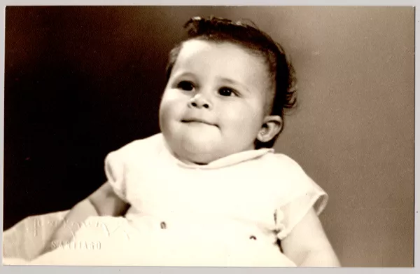 [Niñita sonriente sentada, con un vestido blanco recogido y amplio]  [fotografía] Kyutaro Tunekawa.