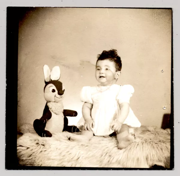 [Niña de vestido blanco con mangas globo y un conejo de peluche; sentada en un felpudo]  [fotografía] Kyutaro Tunekawa.