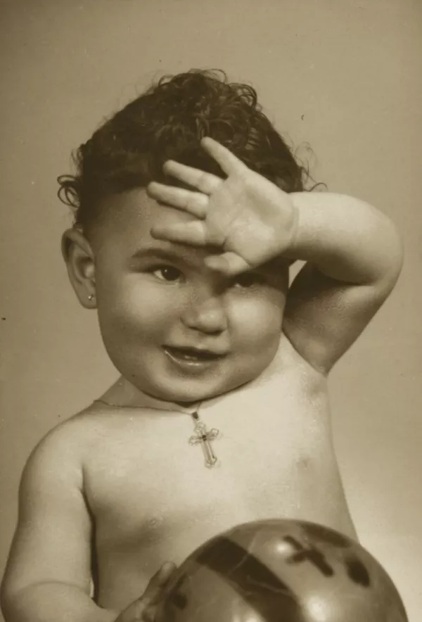 [Niñita desnuda con una pelota en su mano derecha y una cadena con un cristo colgando en el cuello]  [fotografía] Kyutaro Tunekawa.