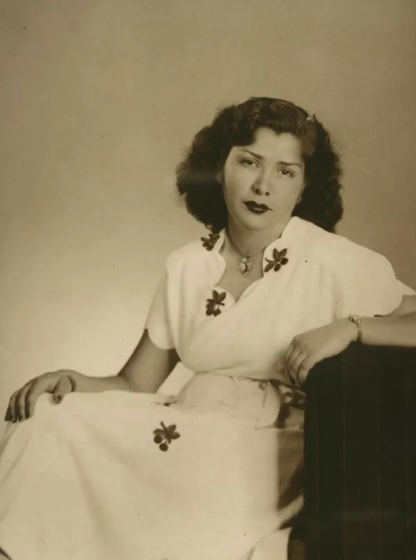 [Mujer de vestido blanco estampado con flores oscuras y un prendedor en el cuello]  [fotografía] Kyutaro Tunekawa.