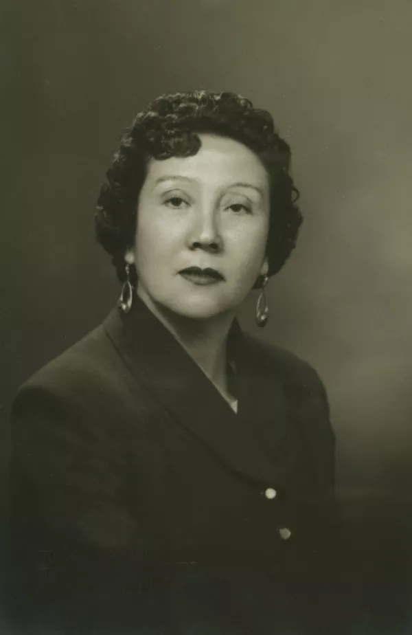 [Mujer adulta de pelo rizado, aretes y traje oscuro]  [fotografía] Kyutaro Tunekawa.