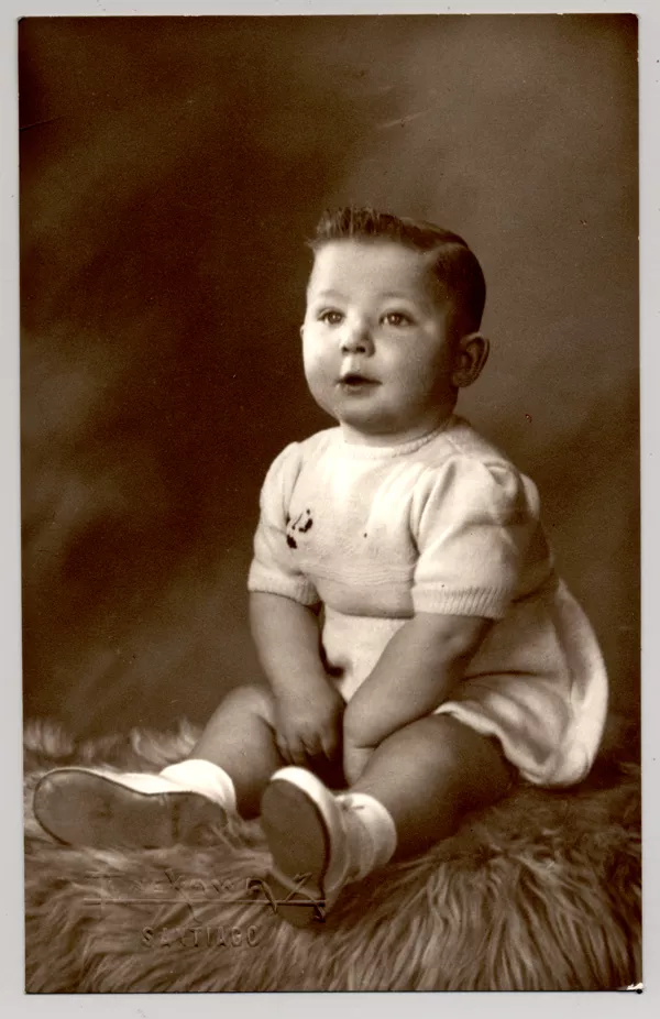 [Niñito rubio de ojos azules, con traje de hilo, zapatos y soquetes blancos sentado sobre un felpudo]  [fotografía]Kyutaro Tunekawa.