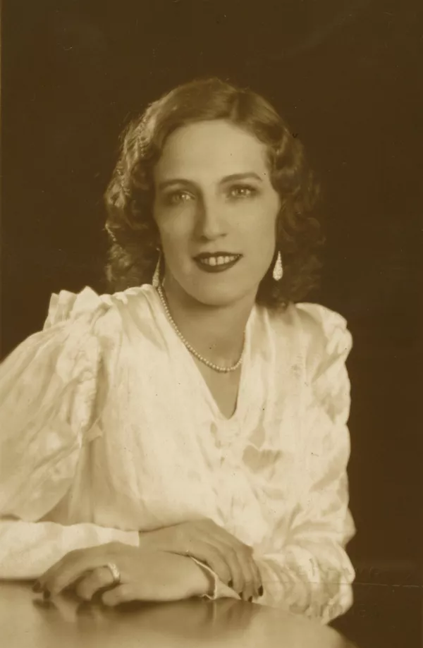 [Mujer joven, vestida elegantemente con una blusa blanca de seda, pelo risado, labios rojos, aros grandes y un collar en su cuello]  [fotografía] Kyutaro Tunekawa,