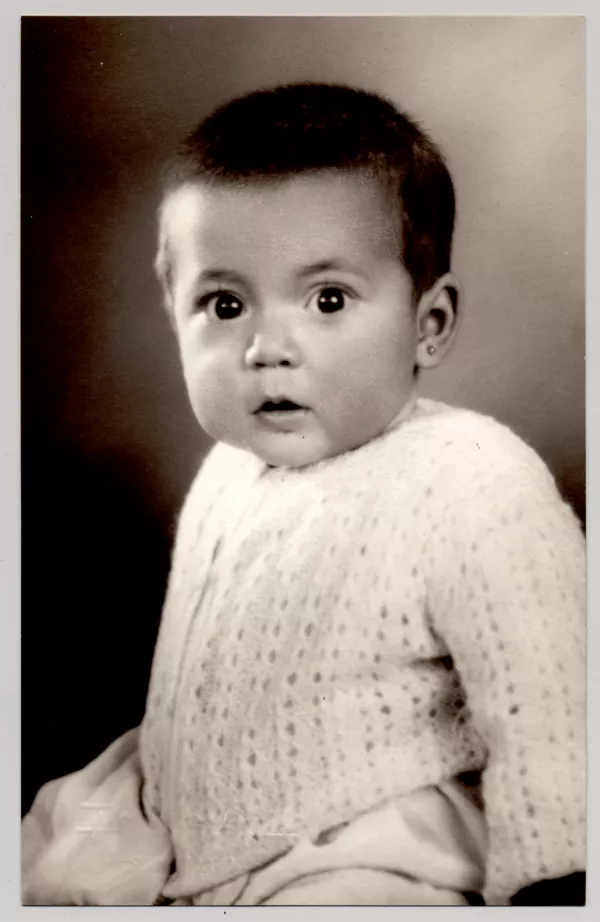 [Bebé con chaleco de lana, vestido blanco y aros]  [fotografía] Kyutaro Tunekawa.
