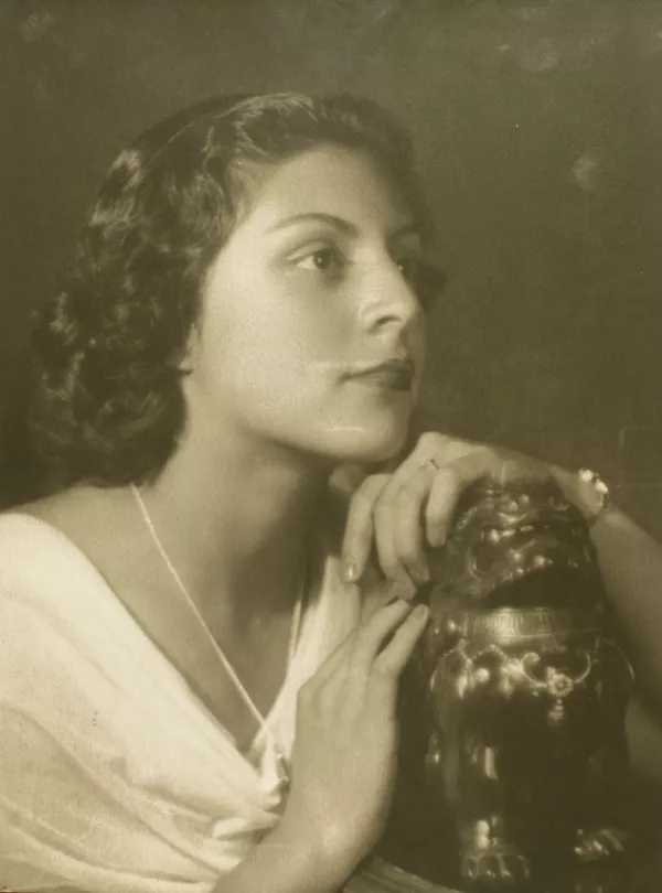 [Joven mujer de vestido blanco con las manos sobre una figura [dragón de plaqué]  [fotografía] Kyutaro Tunekawa.