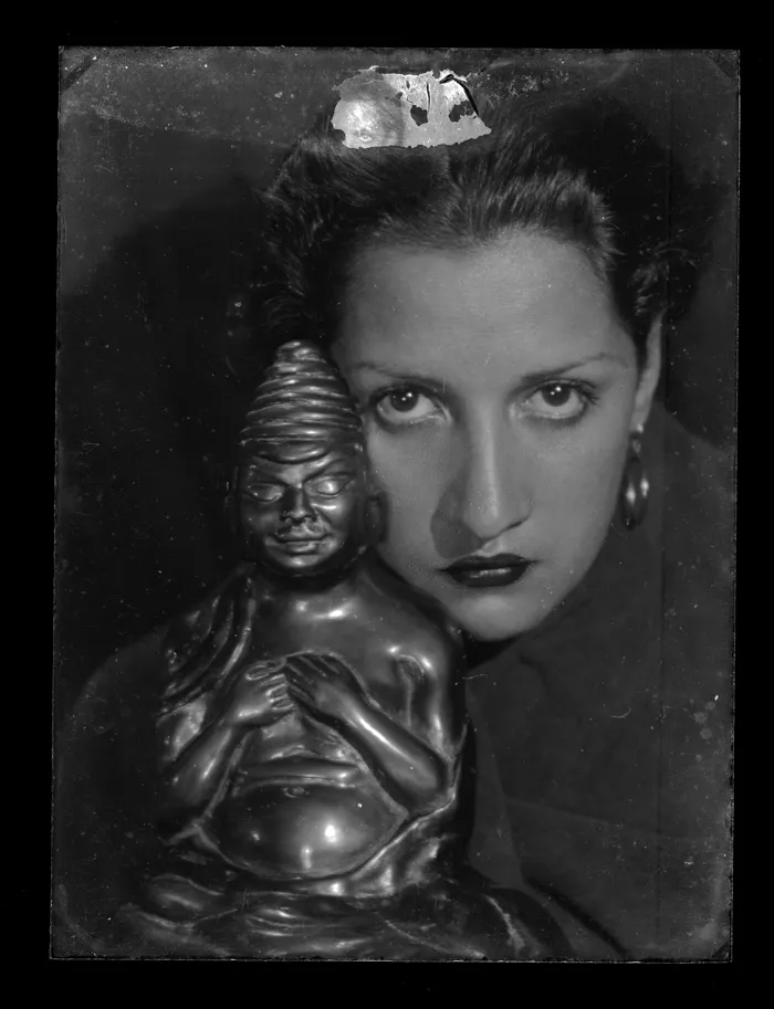 [Rostro de mujer junto a estatuilla]  [fotografía] Alfredo Molina Lahitte.