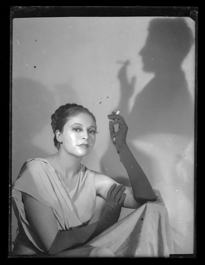 [Mujer sostiene un cigarrillo; en el muro, silueta de un hombre con cigarrillo]  [fotografía] Alfredo Molina Lahitte.