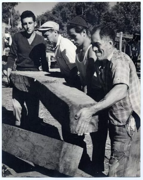 Trabajadores deben mover inmensos bloques de madera que forman parte del esqueleto del lanchón  [fotografía]