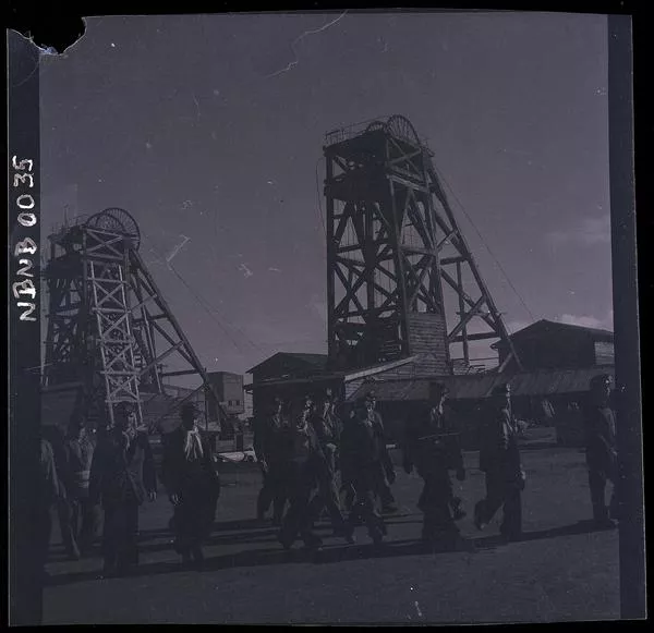 [Grupo de mineros y torres de extracción; exterior de la mina de carbón de Lota]  [fotografía] Ignacio Hochhäusler.