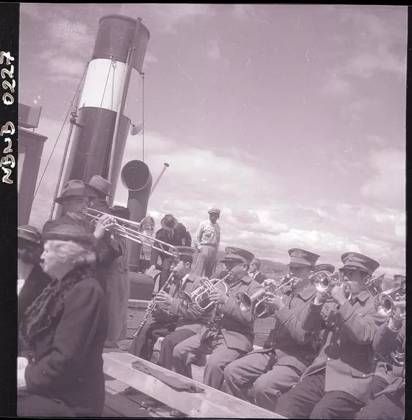 [Banda de música y pasajeros a bordo de un lanchón]  [fotografía] Ignacio Hochhäusler,