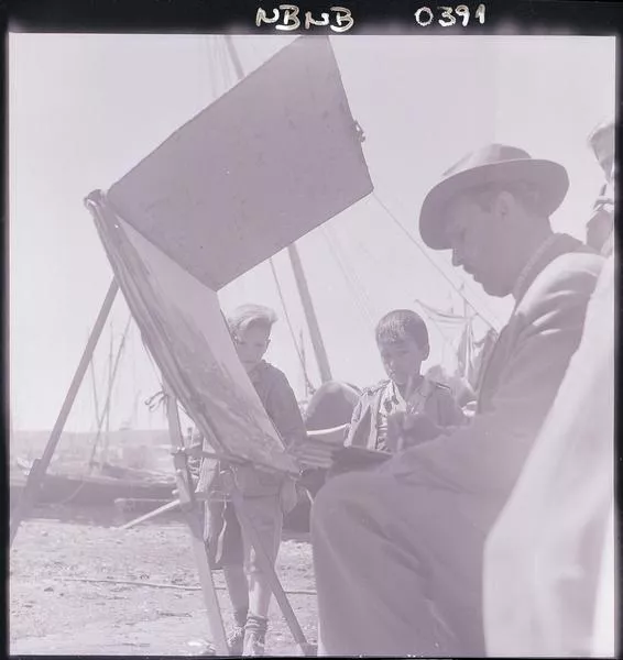 [Niños observan a Héctor Wistuba Lorca, mientras pinta escena de la Caleta de Angelmó]  [fotografía] Ignacio Hochhäusler.