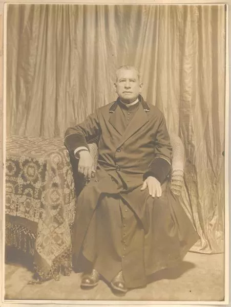 [Sacerdote sentado]  [fotografía].