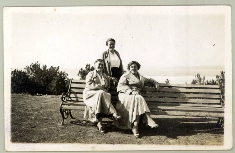 [Mujeres sentadas en una banca en Pichilemu]  [fotografía].