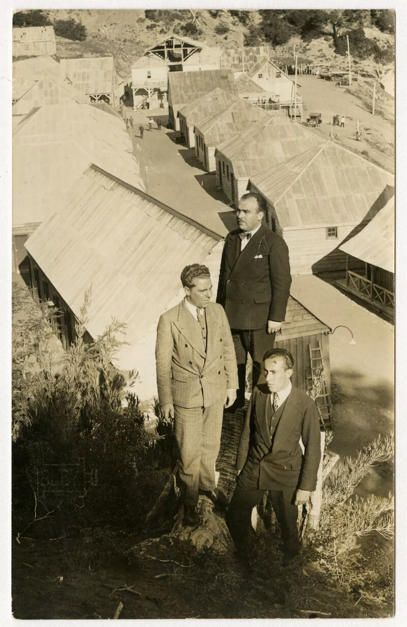 [Hombres en un cerro desde el que se ven las cabañas de las Termas de Chillán]  [fotografía] [Fotografía de Francisco Bley].