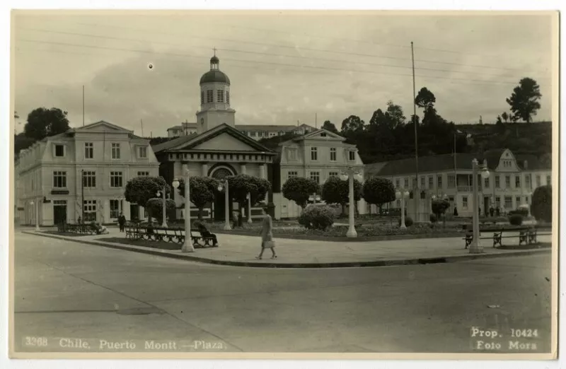 [N.°] 3368.- Chile, Puerto Montt-Plaza [de Armas Buenaventura Martínez Díaz, Catedral de Nuestra Señora del Carmen; Café Olimpia, Hotel Hein y otros edificios] [fotografía] Foto Mora.