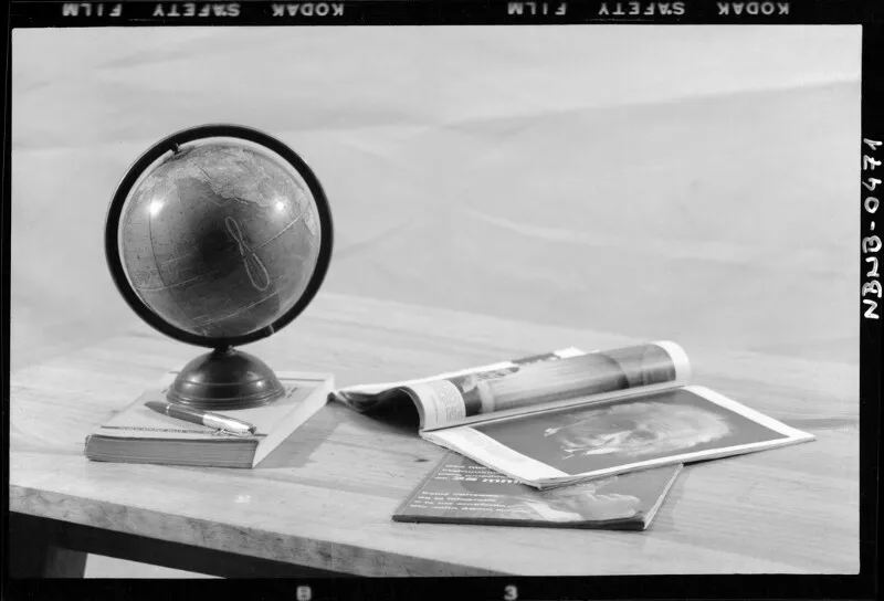 [Globoterráqueo sobre un libro junto a un par de revistas sobre una mesa]  [fotografía] Antonio Quintana.