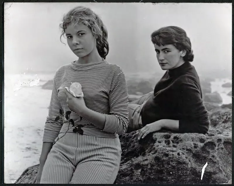[Retrato a la luz del día; una adolescente y su mamá, posan en una roca, con el mar de fondo; la niña sostiene una rosa]  [fotografía] Bob Borowicz.