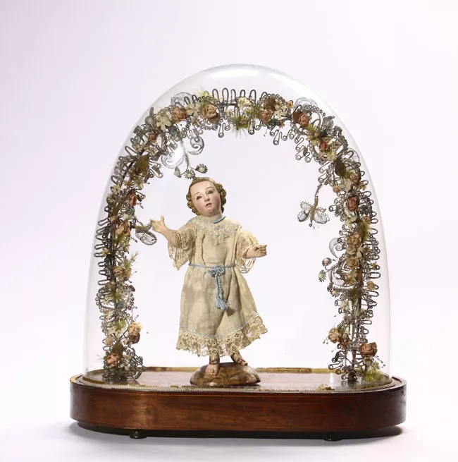 Niño Jesús de pie bajo arco floral