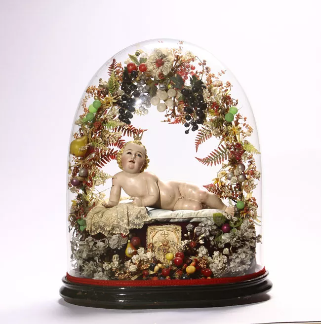 Niño Jesús, recostado bajo arco floral