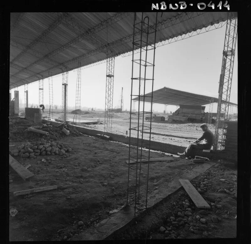 [Hombres trabajando en la construcción de una estructura]  [fotografía] Antonio Quintana.