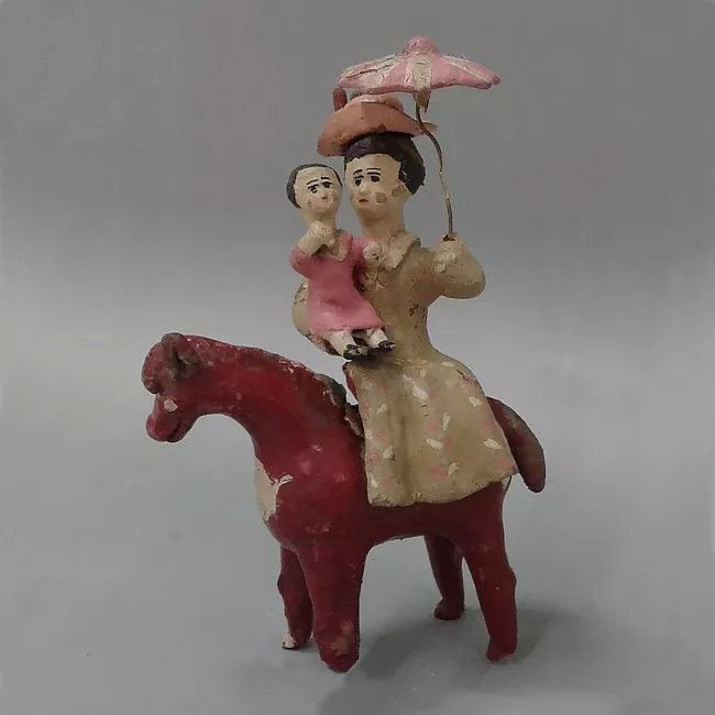 Mujer y niña en brazos a caballo